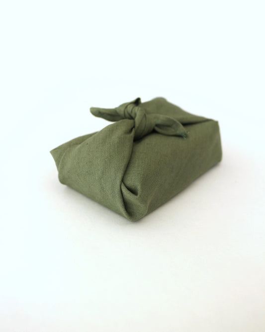 Geschenkverpackung in grün mit Geschenk in anderer Ansicht